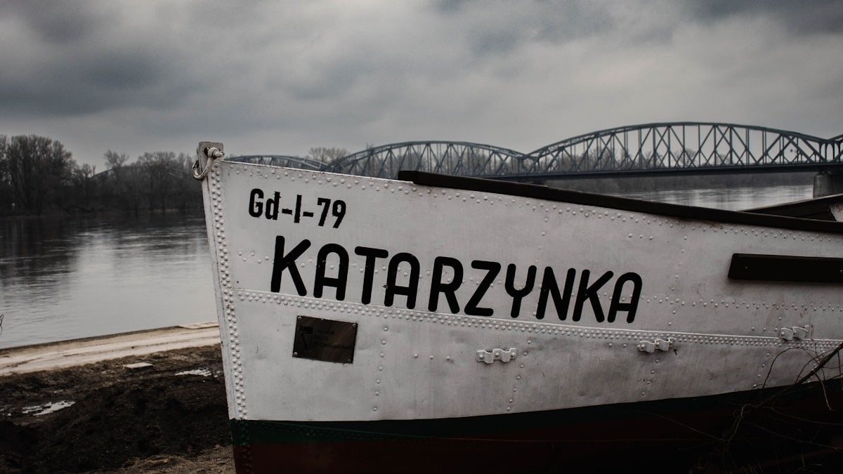 a boat sitting on the shore of a lake